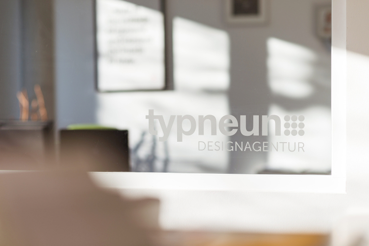 Logo der typneun Designagenetur auf einer Fensterscheibe im Büro